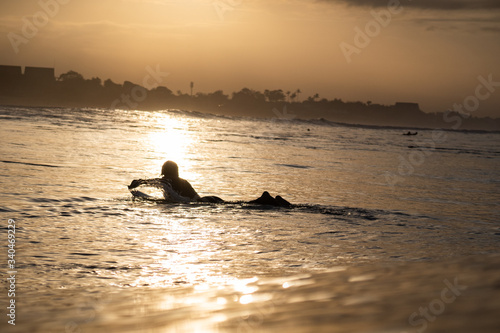 Photography silhouette of man surfing at sunset in the ocean