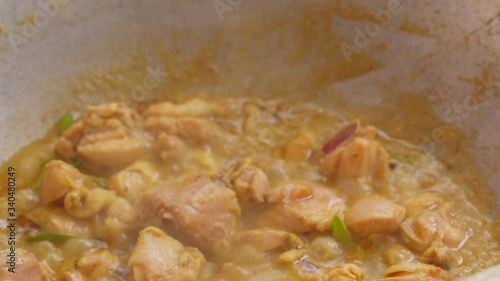 A person is cooking a Thai Spicy Green Curry with Chicken in the kitchen, Till and down photo