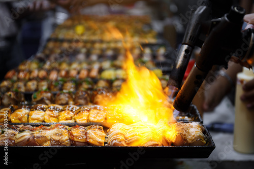 Close up hand of Japanese chef using kitchen torch burn sushi
