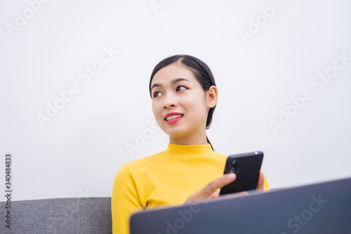 Happy young female surfing the internet shopping online at home after the government announced a ban on leaving the house., Affected by the outbreak of the coronavirus (Covid-19). photo