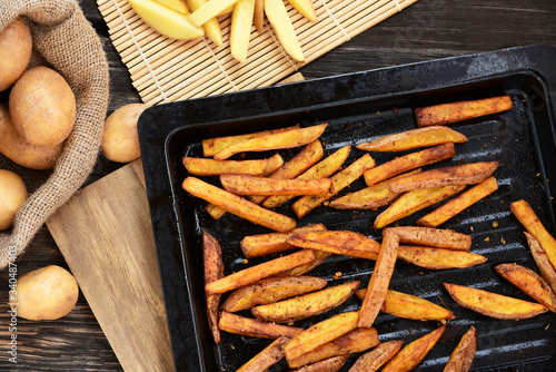 Crispy Oven Baked French Fries for healthy..French fries in black oven tray on wooden board.