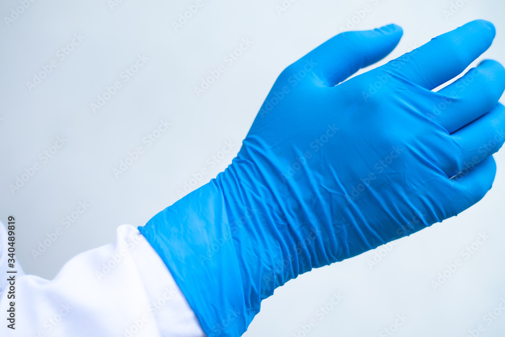 Hand put blue glove on white background. Hand put blue glove on white background.