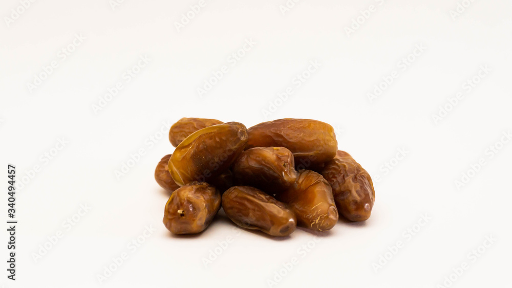 A pile of dates or kurma on isolated white background. A pile of dates or kurma on isolated white background.