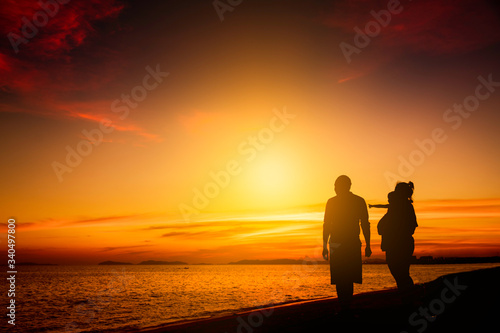 Silhouette family happy on the beach in sunrise or sunset. Freedom life and well being concept