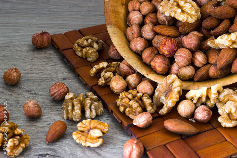 Fototapeta premium Almonds, walnuts and hazelnuts. Without shell. On a gray wooden table.