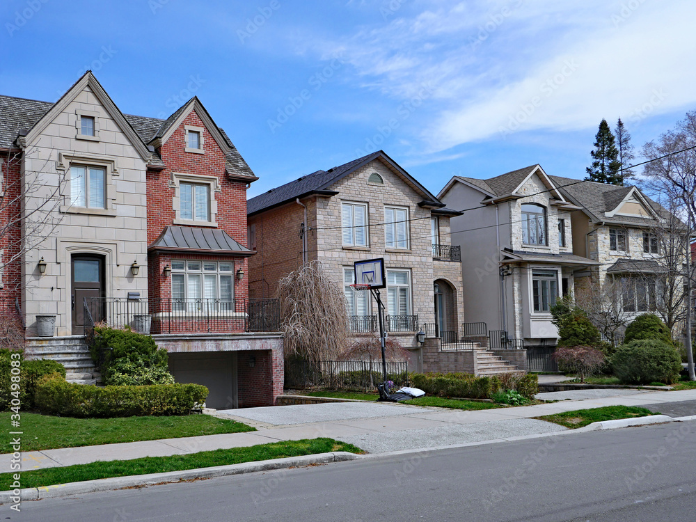 Suburban street with large detached houses with gables