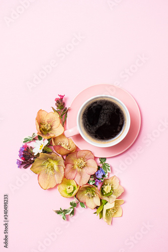 cup of coffee and flowers on the pink background