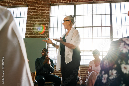 Senior businesswoman talking to a crowd photo