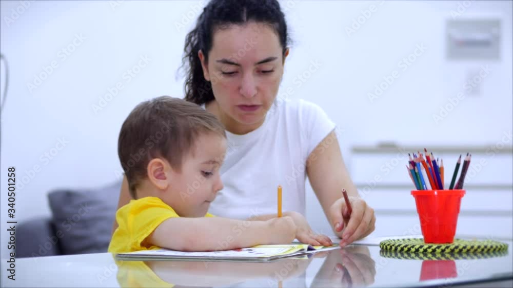 Happy Mother learning cute baby boy playing board games at home, mom helps baby son learn to draw with pencils together enjoy the creative process. Covid-19, virus protection, pandemic in word Happy Mother learning cute baby boy playing board games at home, mom helps baby son learn to draw with pencils together enjoy the creative process. Covid-19, virus protection, pandemic in word