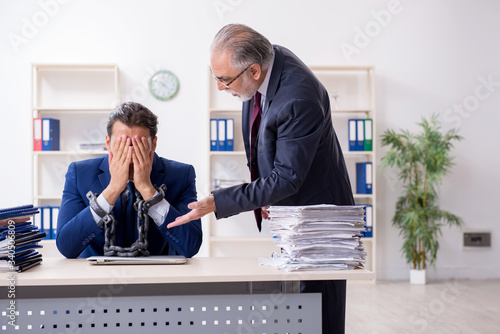 Old boss and young male employee in the office