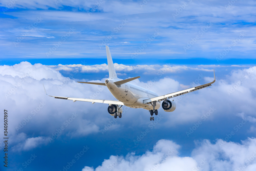 Fototapeta premium Samolot komercyjny lecący nad chmurami, koncepcja podróży.