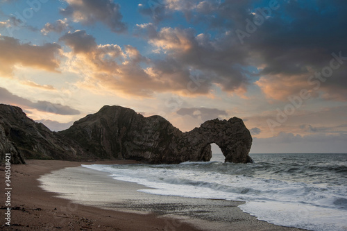 Majestic colorful sunrise over ocean landscape scene with cliffs and beautiful cloud formations