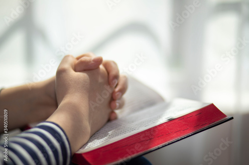 Woman studying the Bible and praying at home, coronavirus, copy space