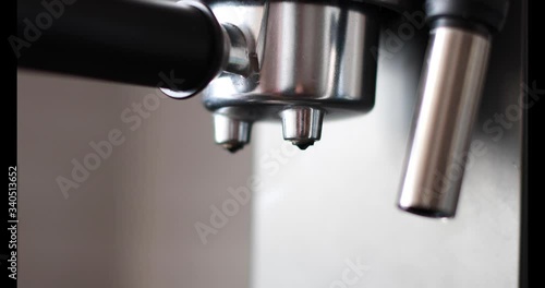 Pouring coffee stream from professional machine in cup. Barista man making double espresso, using filter holder. Flowing fresh ground coffee. Drinking roasted black coffee in the morning