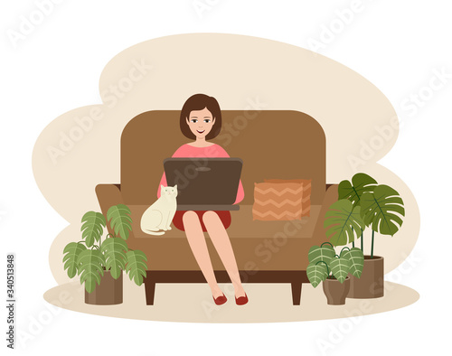 Woman freelancer with a laptop sitting on a sofa. Distance job