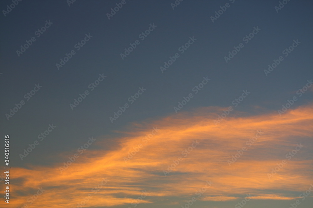 evening clear blue sky with orange sunlight shine through cloud