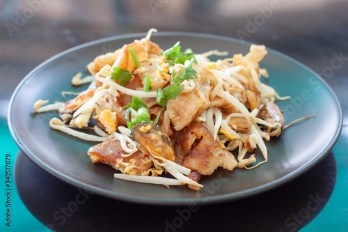 Obraz na plátně Crisp fried mussel pancakes or Mussel omelette in black plate on table background, Thailand call Hoi Tod