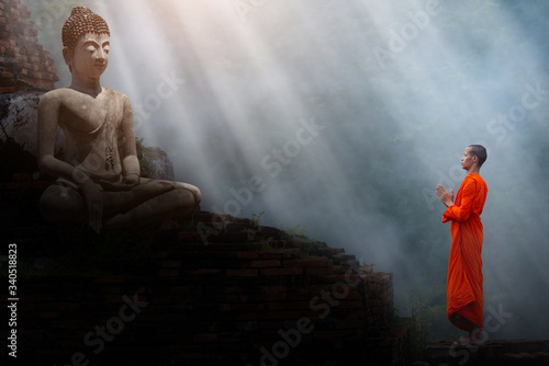 The monks stand to pay respect to the Buddha image.