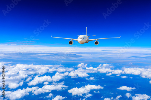 Commercial airplane flying above the clouds travel concept.
