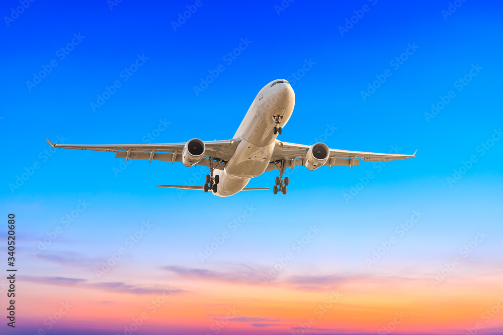 Commercial airplane flying in beautiful sky at sunset,travel concept.