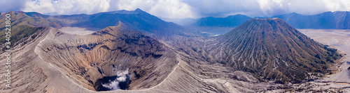 Panoramic aerial view of the Mount Bromo active volcano and Mount Batok cider cone next to the "sea of sand" in Java, Indonesia
