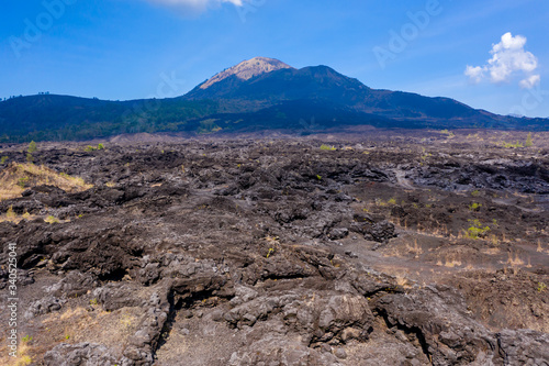 Aerial view of a black volcanic landscape consisting of old lava flows and channels. Mount Batur, Bali, Indonesia