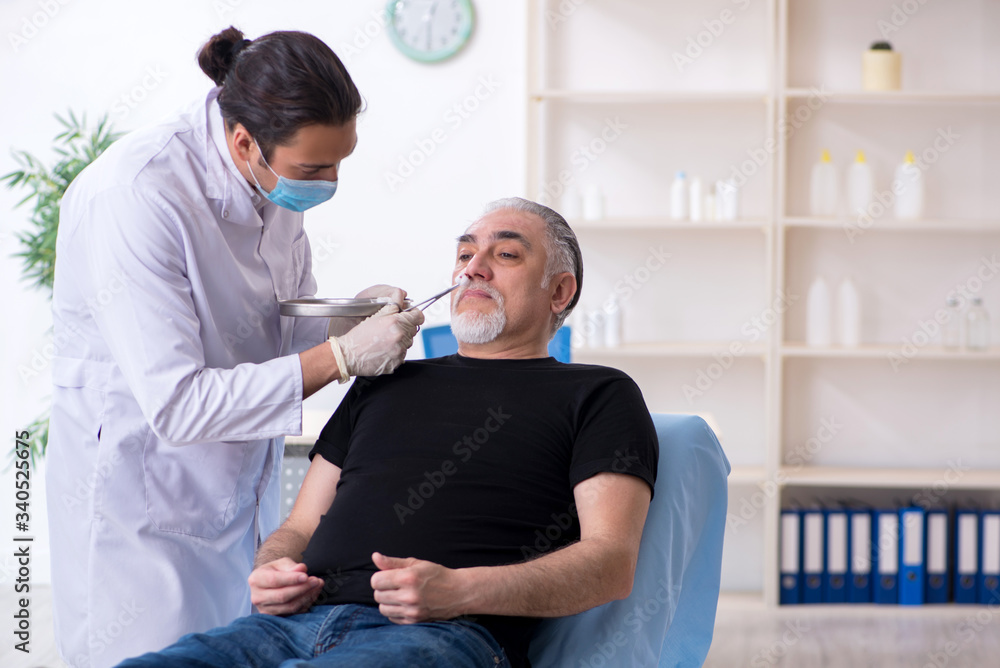 Fototapeta premium Old man visiting young doctor for plastic surgery
