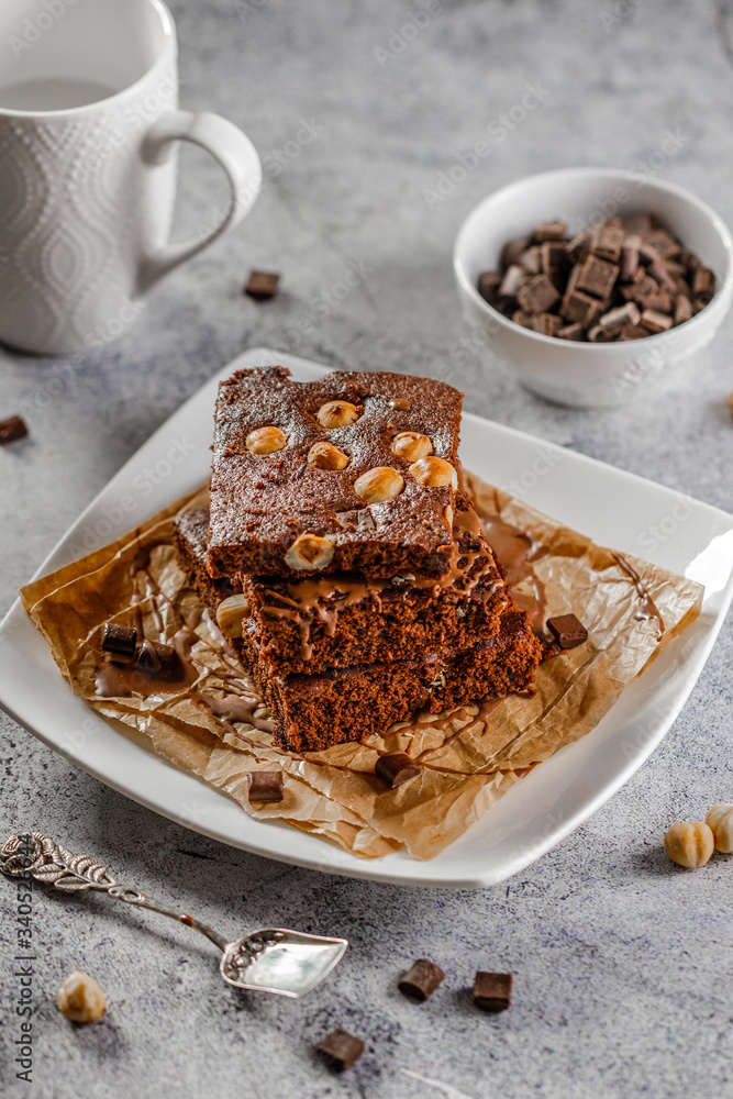 brownie cake wit hazelnut and chocolate on concrete table brownie cake wit hazelnut and chocolate on concrete table