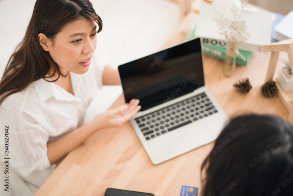 Young Asian man and woman are talking about business meeting and present by computer laptop on wood table in white room at home office which glad smiling and felling happy. people work at home. Young Asian man and woman are talking about business meeting and present by computer laptop on wood table in white room at home office which glad smiling and felling happy. people work at home.