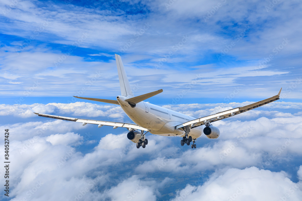 Obraz premium Commercial airplane flying above the clouds,travel concept.
