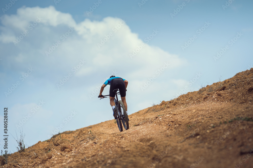 Mountain biker cycling, training and going up a steep climb.