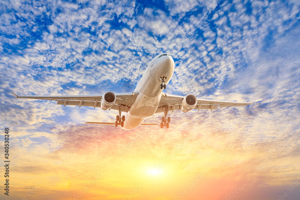 Fototapeta premium Commercial airplane flying in beautiful sky at sunset,travel concept.
