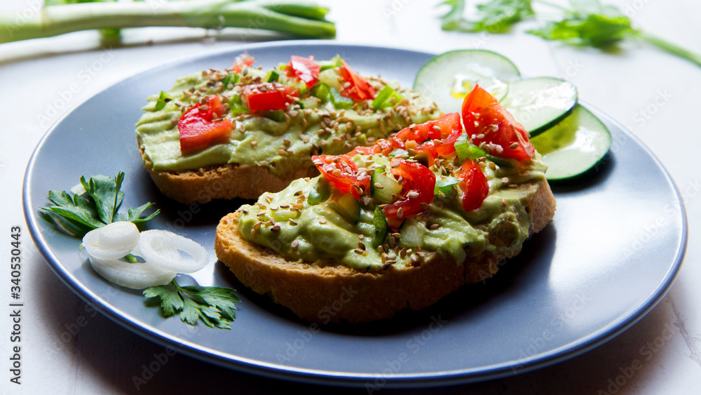 Avocado bruschetta with cherry tomatoes and cucumber Avocado bruschetta with cherry tomatoes and cucumber