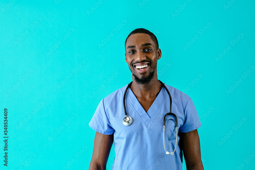 Portrait of a happy male doctor or nurse wearing blue scrubs uniform and  smiling, isolated on blue studio background foto de Stock | Adobe Stock
