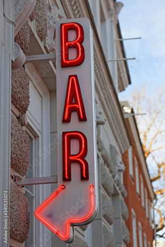 bar sign with arrow outside a building in the city center