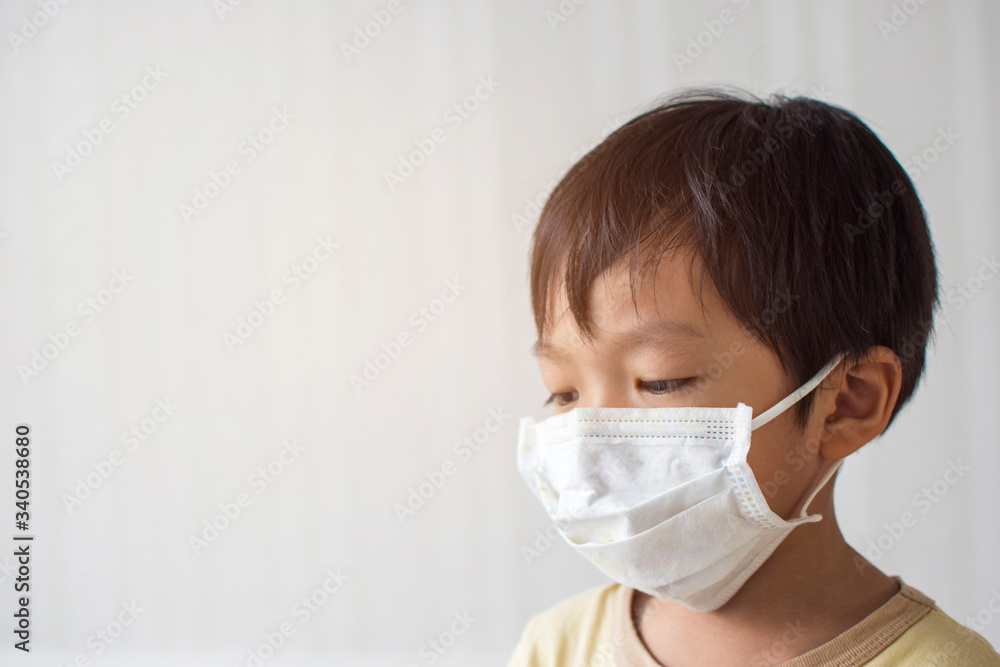 Asian young boy wearing a medical mask for against infection and prevent spread of Coronavirus with copy space,Covid-19 prevention.