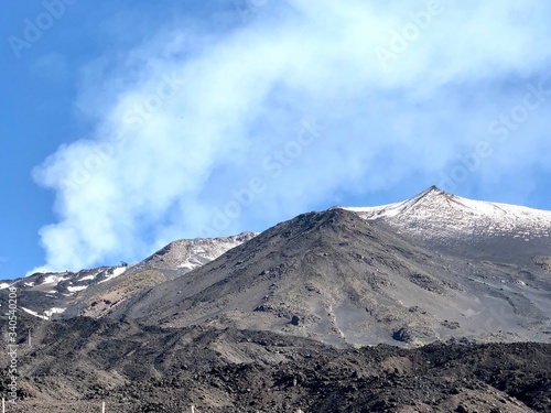 Snow-covered hills of Etna volcano covered with ashes, Sicily, Italy