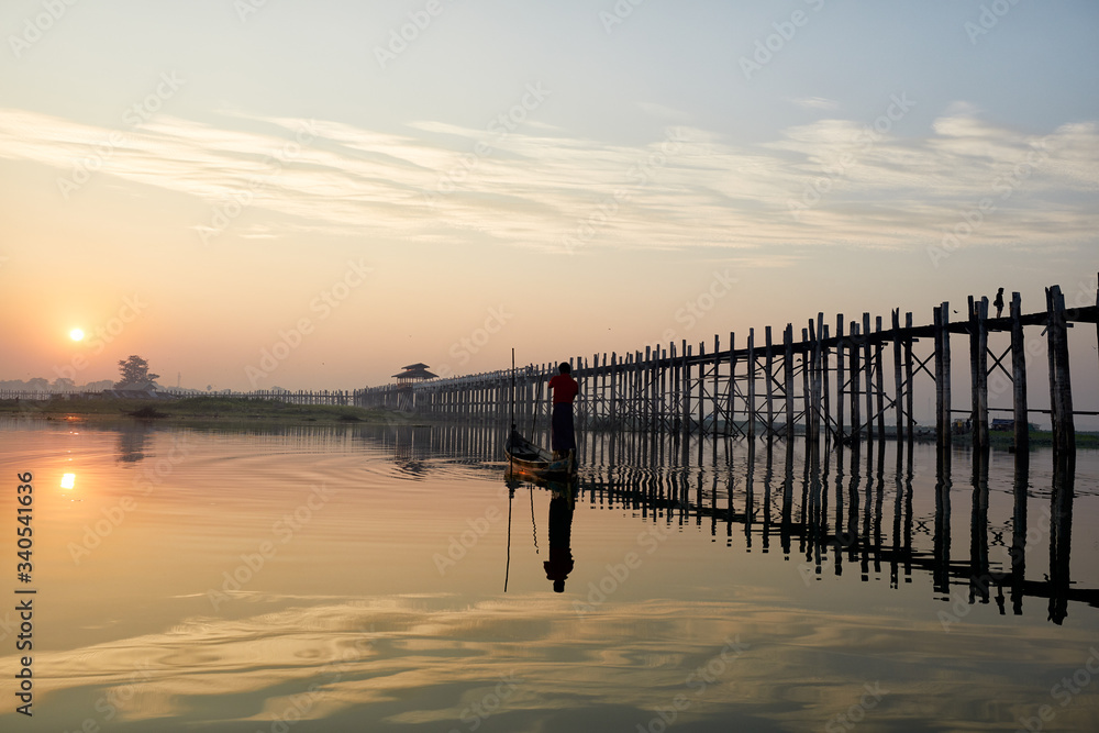 A silhouette of a fisherman at dawn near U Bein Bridge, Mandalay, Myanmar.