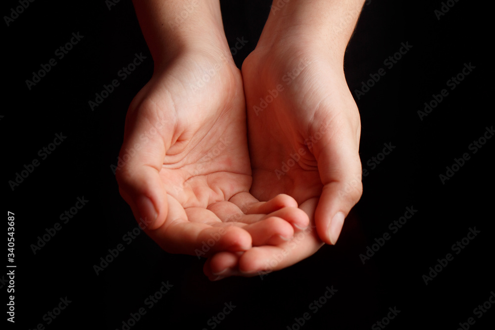 Fototapeta premium Children's open palms are on a black background.