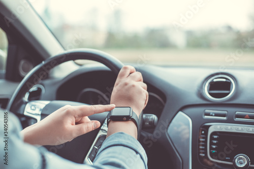 Close up of woman using smart watch during driving her car, transport concept © Khaligo