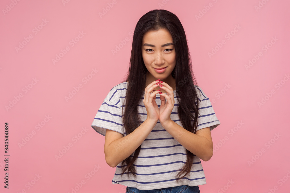 Portrait of beautiful asian girl with long brunette hair scheming evil idea and looking at camera with slyly expression, having tricky devious plan in mind. studio shot isolated on pink background Portrait of beautiful asian girl with long brunette hair scheming evil idea and looking at camera with slyly expression, having tricky devious plan in mind. studio shot isolated on pink background