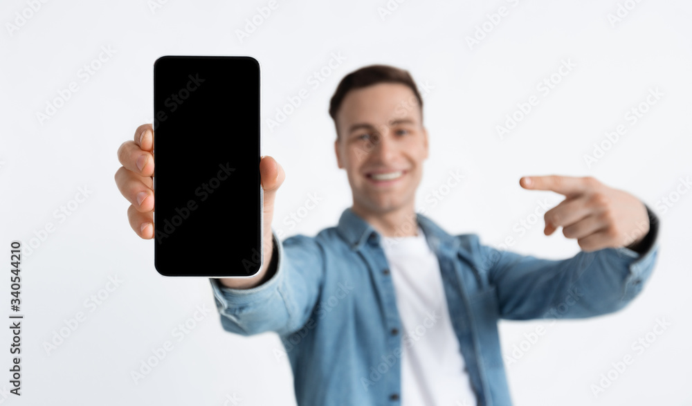 Focus on blank screen. Guy points finger at smartphone Focus on blank screen. Guy points finger at smartphone