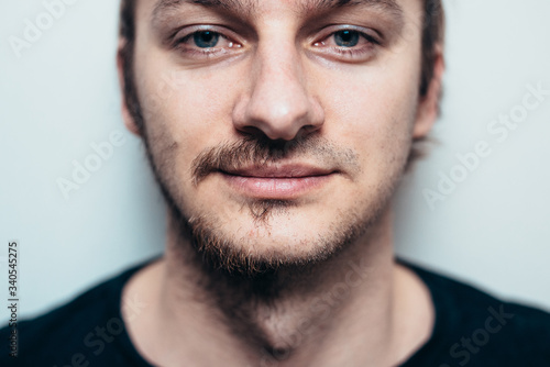 A close portrait of a shaved man on one side only.