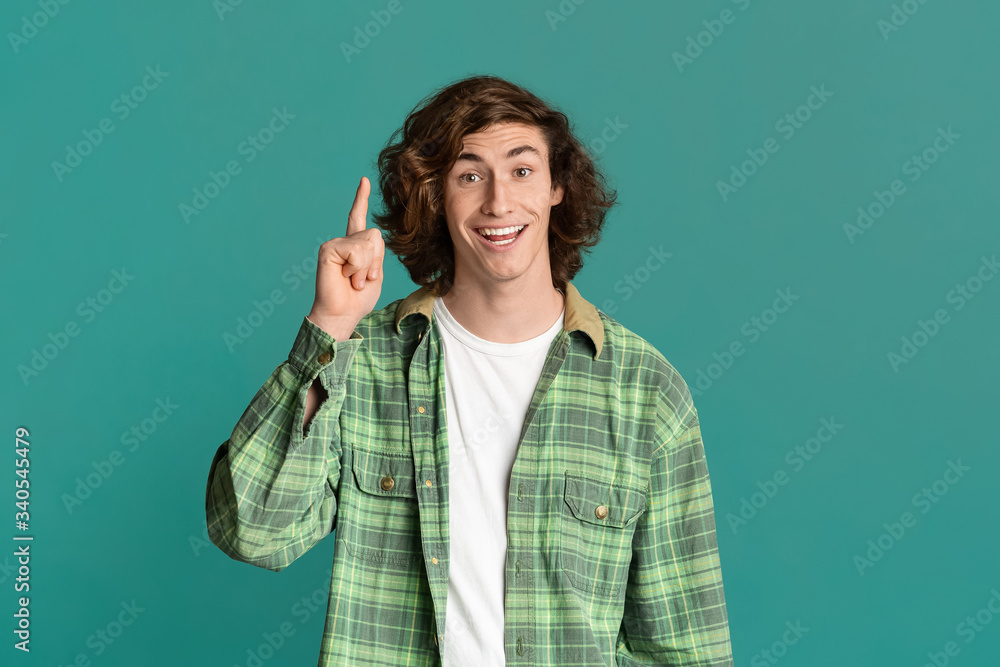 Cheerful young guy having brilliant idea, gesturing EUREKA on turquoise background Cheerful young guy having brilliant idea, gesturing EUREKA on turquoise background