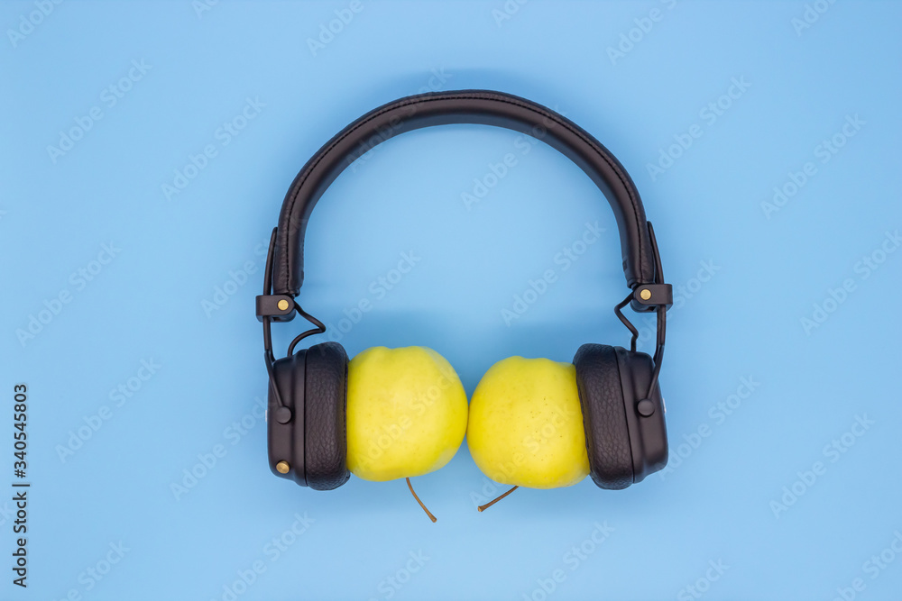 Two apples in the headphones, the concept of sharing music, friendship, love and spending time together