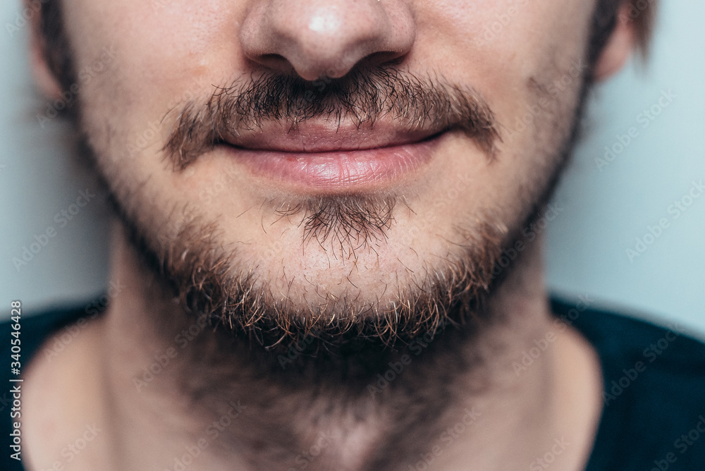 Close portrait of an unshaven man with a mustache and beard. Close portrait of an unshaven man with a mustache and beard.