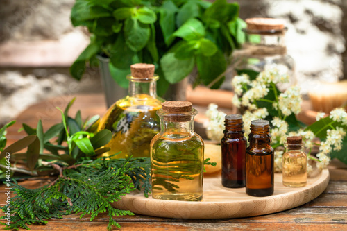 Assortment of natural oils in glass bottles on wooden background. Concept of pure organic ingredients in cosmetology. Atmosphere of harmony, relax, spa. Close up macro. Healthy lifestyle
