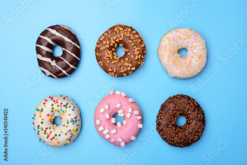 Set of yummy colorful pastel retro summer fashion donuts. Top above overhead flat-lay photo of six beautiful sugary objects isolated over blue background