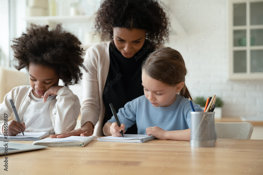 Young African American mother help multiracial daughters with homework, study together online at home, biracial mom and multiethnic girls sisters have web class or lesson, homeschooling concept Young African American mother help multiracial daughters with homework, study together online at home, biracial mom and multiethnic girls sisters have web class or lesson, homeschooling concept