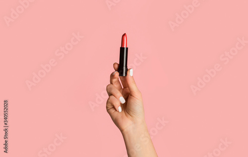 Fashion and makeup. Closeup of girl showing red lipstick on pink background photo